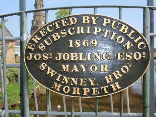 1869 brass plaque on a footbridge over the River Wansbeck, Northumberland.