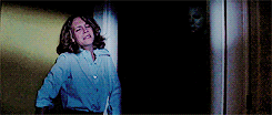A still of Michael Myers sneaking up on Laurie Strode in Halloween.