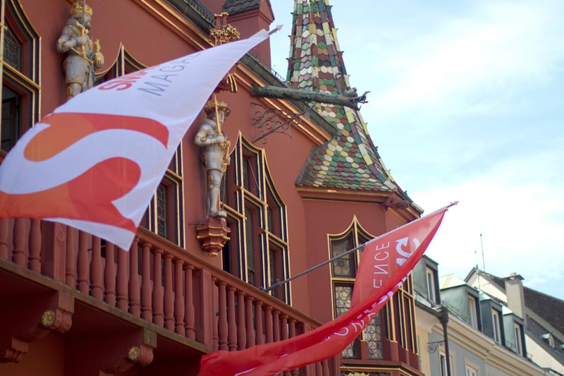 Smashing Flags waving in front of the historic Merchant's Hall in Freiburg