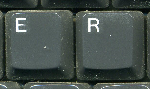 zoomed in view of 2 dusty keyboard keys, E and R