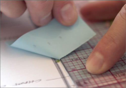 Ripping a sticky note with a ruler.