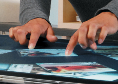Multi-touch table with a photo sorting application running on it.