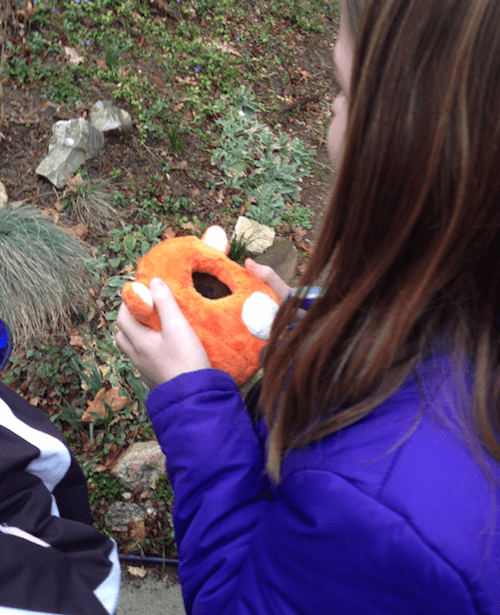 Child participant playing with Ubooly outside with her sister.