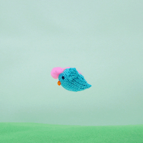 An animated GIF, a yarn bird pooping out hearts