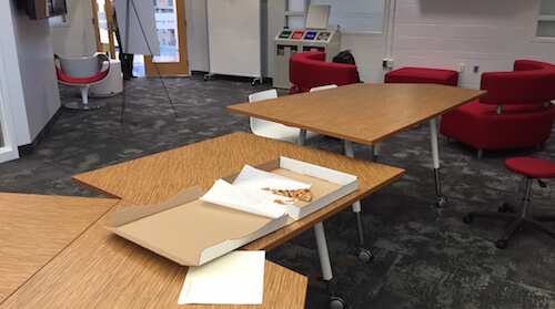 An almost-empty pizza box sitting on a table.