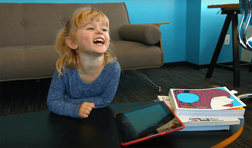 Usability Testing Picture of a child laughing close to a tablet